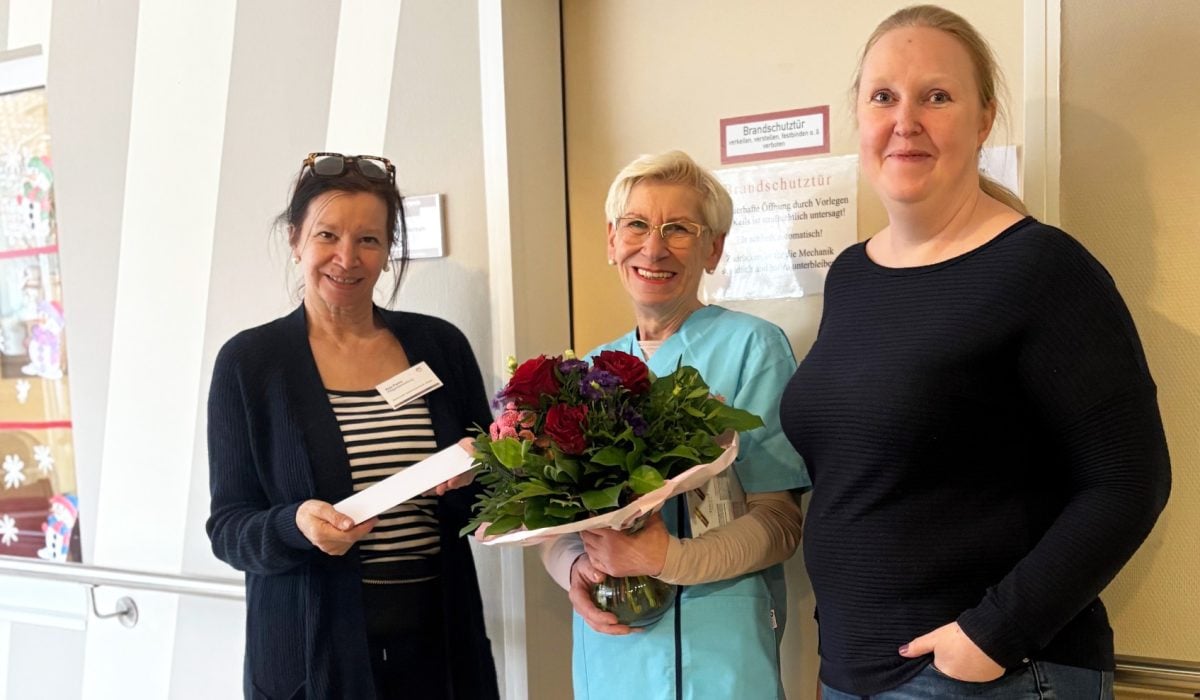 Pflegedienstleiterin Anja Panitz (links) und Einrichtungsleiterin Antina Behrmann gratulieren Maria Winkler zum runden Dienstjubiläum. Foto: Bonmonde • Laura Theocharakis
