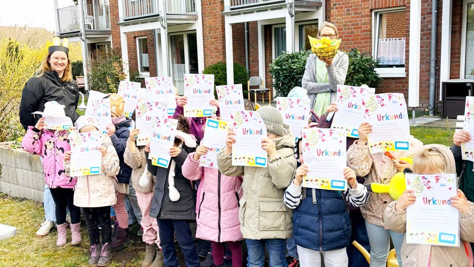 Stolz halten die Mädchen und Jungen der Kita-Aligse ihre Urkunden vors Gesicht. Alle haben erfolgreich am Ostereiersuchen im Bonmonde Seniorenzentrum teilgenommen.
