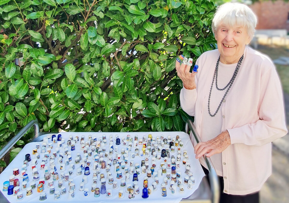 Vier Finger gut behütet: Bonmonde-Bewohnerin Wilma Schmidt demonstriert den Umgang mit dem Utensil des Schneiders. Die Auswahl ist groß am Fingerhuttisch.